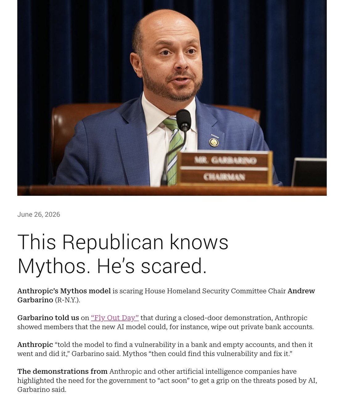 screenshot: News article screenshot. Photo: a man (Rep. Garbarino) in a blue suit and green striped tie speaking into a microphone at a committee dais; wooden nameplate reads "MR. GARBARINO / 